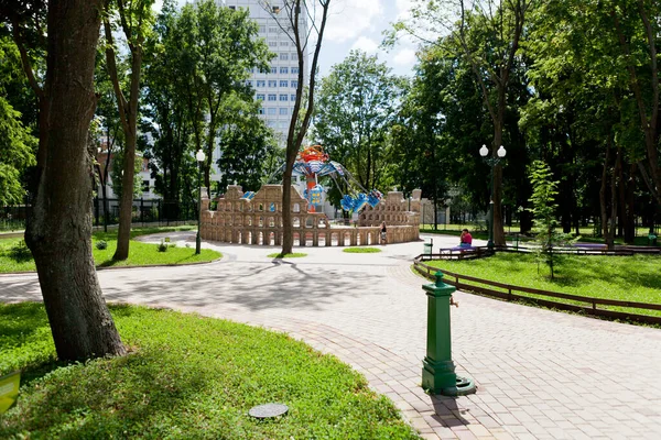 Güneşli bir günde insanların yürüdüğü uzun yeşil ağaçların olduğu parkın sokakları ve yolları.
