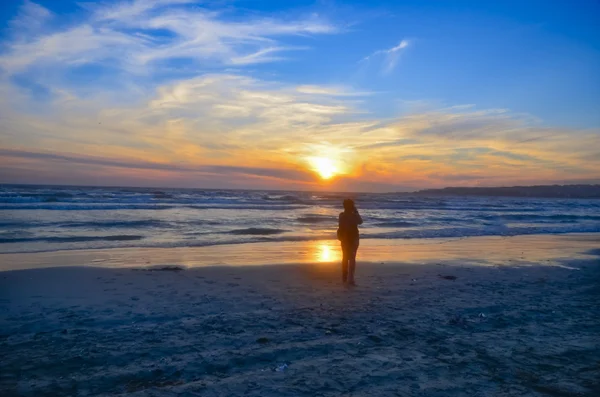 Beach silhouettes of people, sunset — Stock Photo, Image