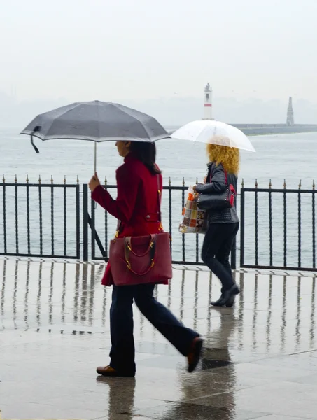 Istanbul 'da sisli yağmurlu bir gün. Feribot iskelesine giden iki kadın