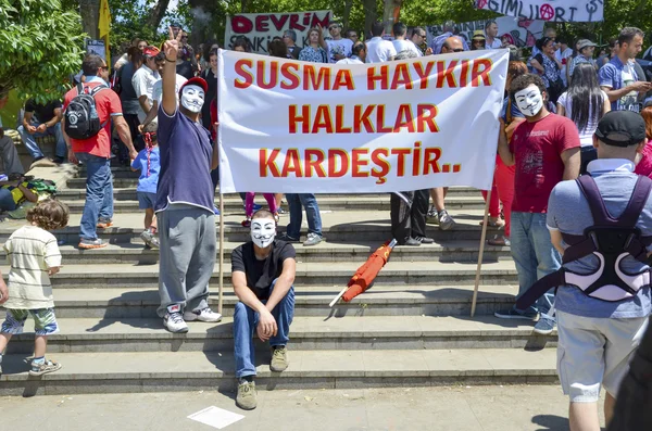 Guy Fawkes maskerade demonstranter med plakat i Gezi Park. — Stockfoto
