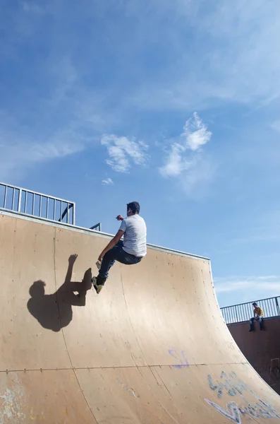 Patinadores jovens sob o céu azul parece quase como voar — Fotografia de Stock