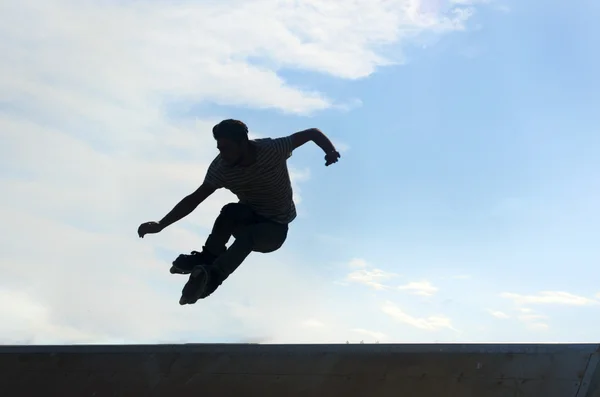 Jóvenes patinadores bajo el cielo azul parece casi como volar — Foto de Stock