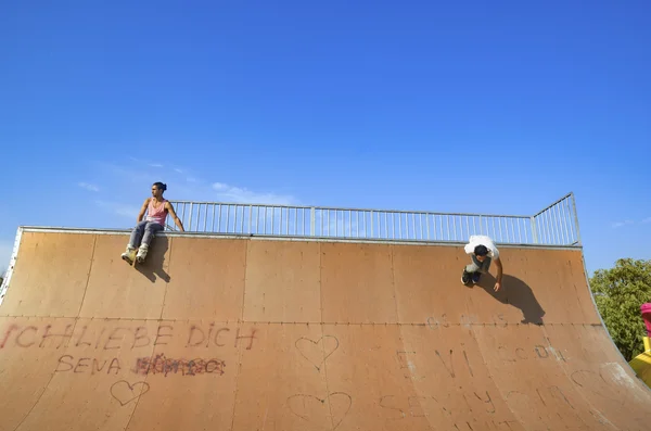 Jonge schaatsers onder de blauwe hemel bijna lijkt voor flying — Stockfoto
