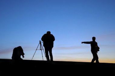 Sunrise silhouette of photographers shooting clipart
