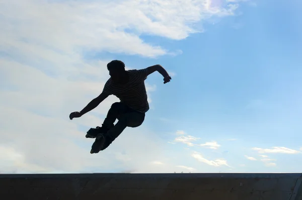 Patinadores jovens sob o céu azul parece quase como voar — Fotografia de Stock