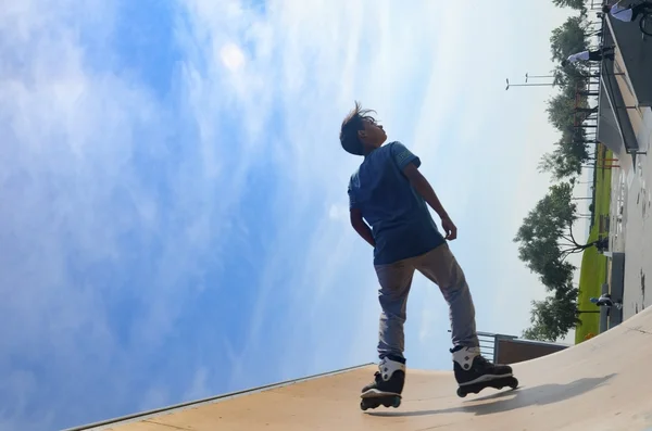 Patinadores jovens sob o céu azul parece quase como voar — Fotografia de Stock