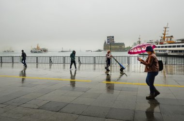 Istanbul Vapur İskelesi insanlar yağmur altında.