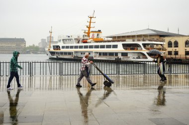 Istanbul Vapur İskelesi insanlar yağmur altında.