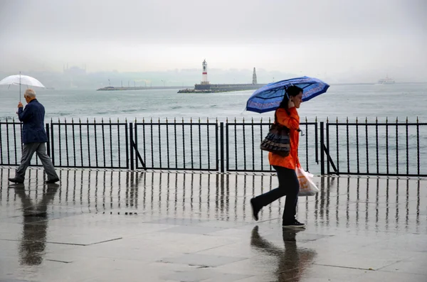 Istanbul jetée de bateau à vapeur personnes marchant sous la pluie . Image En Vente