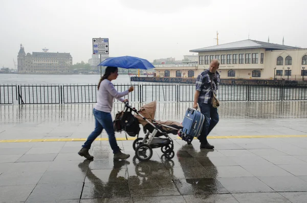 Istanbul Vapur İskelesi insanlar yağmur altında.