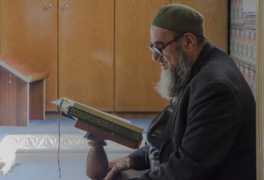 Muslims find peace by reading the Quran at the mosque clipart