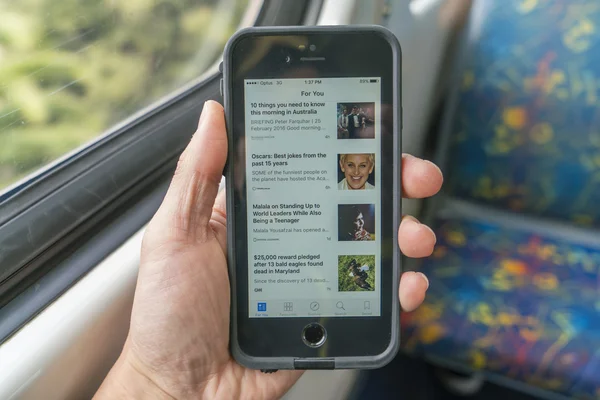 Usando o iPhone no trem durante o deslocamento — Fotografia de Stock