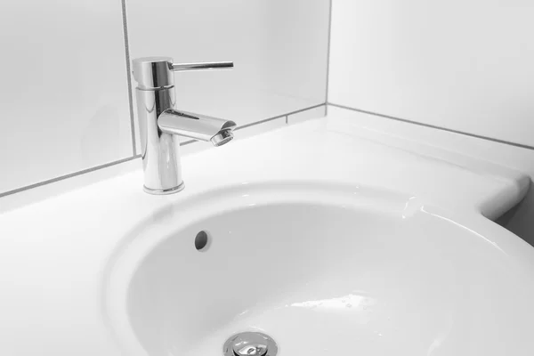 Wasserhahn und weißes Waschbecken im Badezimmer — Stockfoto