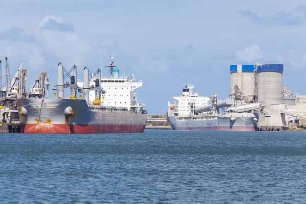 Navios de carga que descarregam num porto — Fotografia de Stock