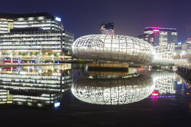 View of Webb Bridge and modern buildings in Docklands, Melbourne at night clipart