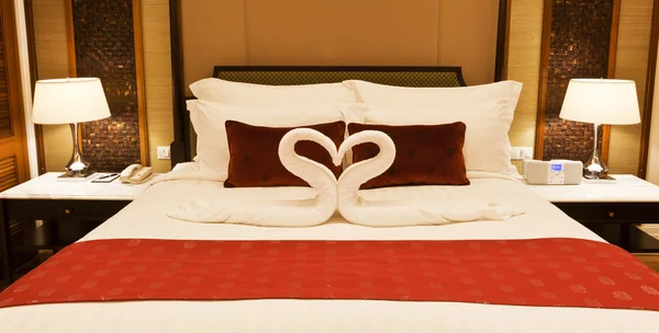 Hotel room with towel forming heart shape — Stock Photo, Image