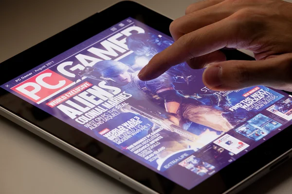 Revista de leitura usando um tablet — Fotografia de Stock