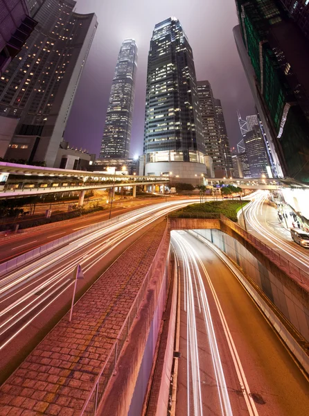 Modern buildings at night with traffic trails — Stock Photo, Image