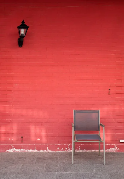 Chaise et lampe contre mur de briques — Photo