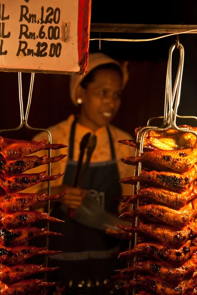 Vendedor malayo que vende alitas de pollo en un mercado de alimentos — Foto de Stock