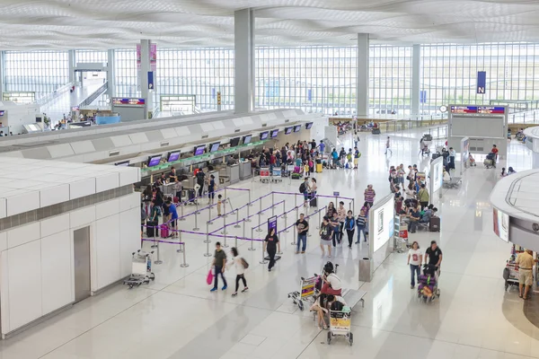 Viajantes nos balcões de check-in de um aeroporto — Fotografia de Stock