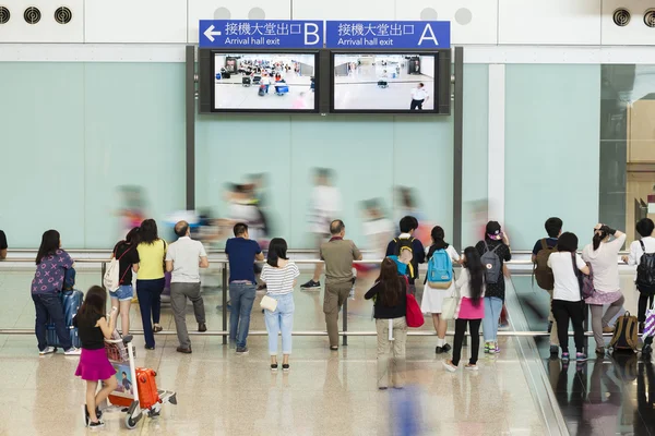 Personas en la sala de llegadas de un aeropuerto — Foto de Stock