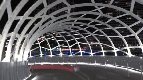 Gesichtsaufnahme von Spaziergängen entlang der Webbrückenbrücke in den Docklands, Melbourne bei Nacht — Stockvideo