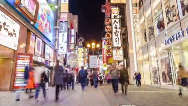 Timelapse video de turistas visitando una calle comercial por la noche — Vídeo de stock