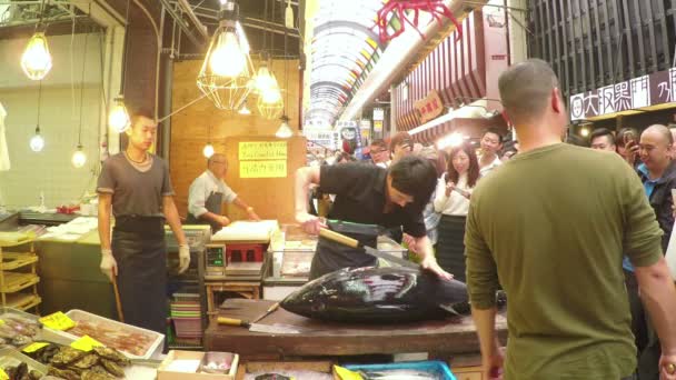 Video de cortar un atún gigante en una tienda de mariscos en un mercado en Japón — Vídeos de Stock