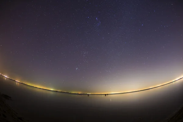 Starry night sky over clam water — Stock Photo, Image