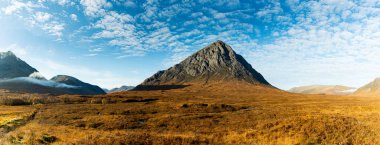 İskoçya 'nın dağlık bölgelerinin Argyll bölgesinde Glencoe ve Rannoch' un kıyısındaki Munro Dağı Buachaille Panorama Etive Mor parlak mavi bir sonbahar gününde Mackerel bulutlarıyla.
