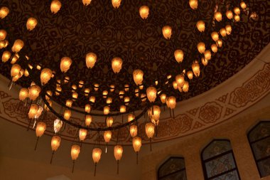 Caminin içi görkemli, büyük bir avizeyle aydınlatılmış.