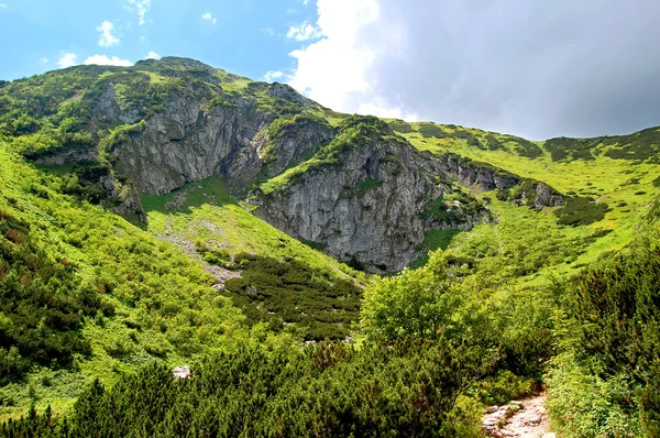 Declive de montanha rochosa coberto com grama — Fotografia de Stock