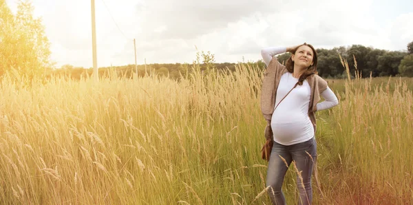 Unga gravid kvinna utomhus i sommardag — Stockfoto