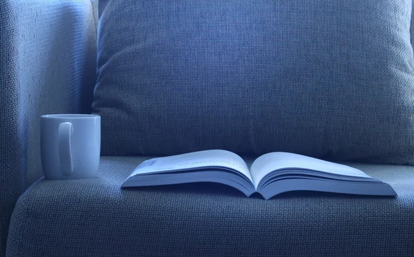Yatakta bir fincan kahve ile açık kitap