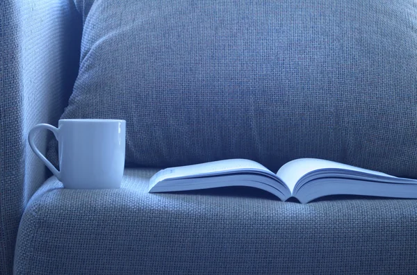 Yatakta bir fincan kahve ile açık kitap