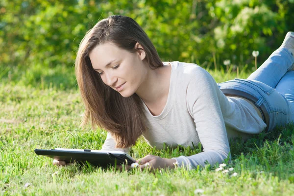 Młoda kobieta przy użyciu komputera typu Tablet odkryty w parku — Zdjęcie stockowe