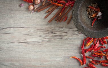 Kurutulmuş biber ve baharat ahşap bir masa üzerinde bir taş harç.