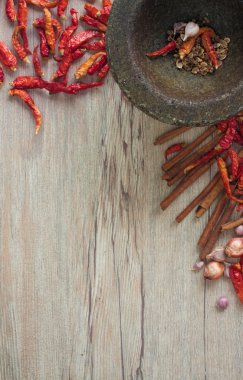 Kurutulmuş biber ve baharat ahşap bir masa üzerinde bir taş harç.