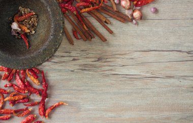 Kurutulmuş biber ve baharat ahşap bir masa üzerinde bir taş harç.