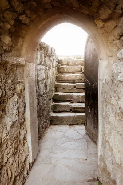 Кам'яна стіна з відкритими дверима і променями світла позаду — стокове фото
