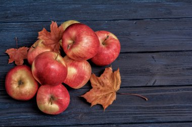 Elma ve mavi koyu ahşap arka plan yapraklarda