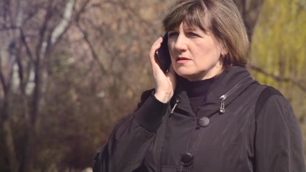 Kvinna pratar i telefon utomhus — Stockvideo