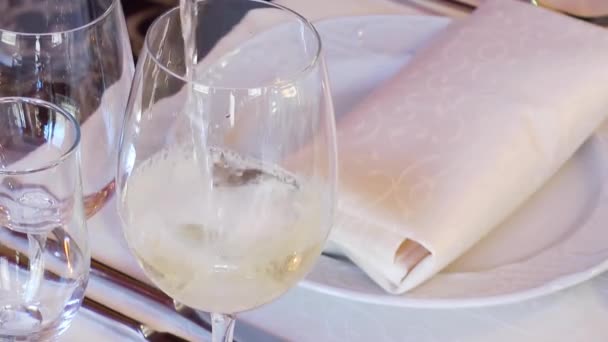 Weißwein wird in ein Glas gegossen — Stockvideo