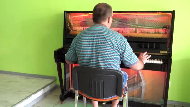 Un hombre tocando un piano transparente — Vídeos de Stock