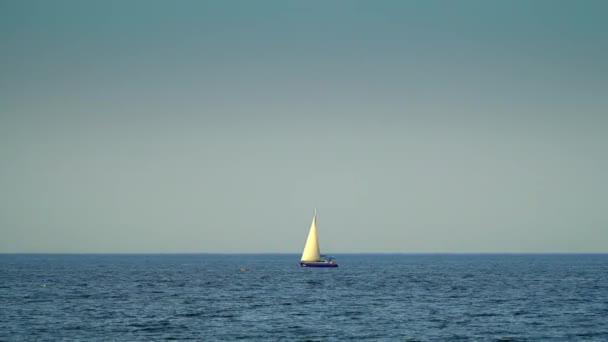 Yachten med sejl flyder på havet. På baggrund af himlen – Stock-video