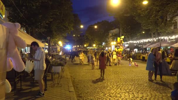 Odessa, Oekraïne - 26 juni 2016: Mensen lopen in de nacht van feestelijke straat. We zien mensen, paard, kleine eethuisjes — Stockvideo