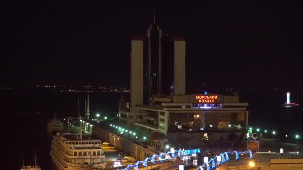 Odessa, Ucrania - 26 de junio de 2016: Vista superior del puerto deportivo nocturno. Barcos de motor visibles del, edificios, faro iluminado — Vídeos de Stock