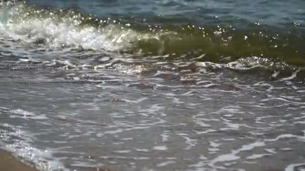 Movimento lento. Ondas do mar correm na praia arenosa — Vídeo de Stock