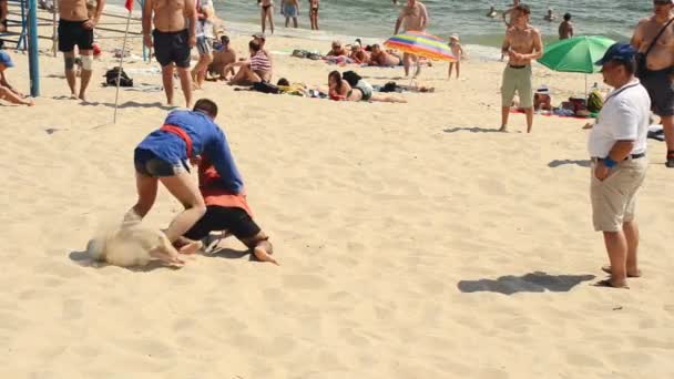 De strijd van jonge mensen op het strand — Stockvideo